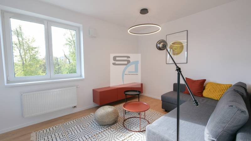 Nappali egy kétszobás lakásban fa dekor padlóval és kanapéval.