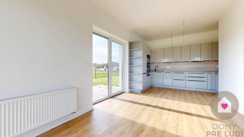 Konyha és nappali rész egy 3 szobás lakásban nagy ablakokkal és kilátással a zöldre.