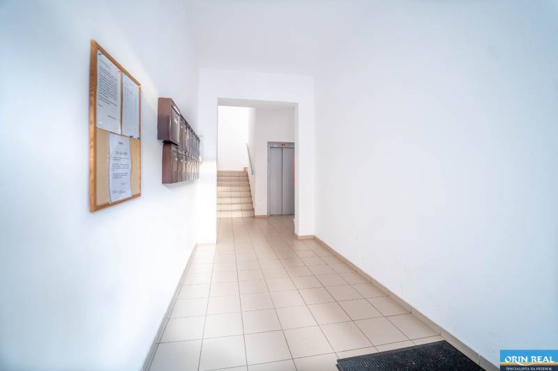 Lakóház bejárat postaládákkal és lifttel, alkalmas 2 szobás lakás számára.