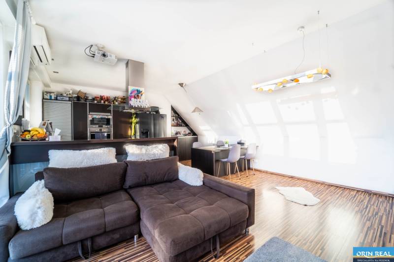 Nappali konyhasarokkal, kanapéval és fa dekorációjú padlóval, 2 szobás lakás.