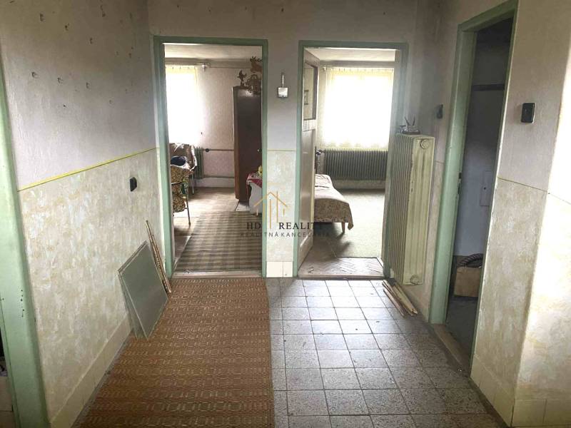 Családi ház belső tere folyosóval és szobák bejáratával, fa dekoros padlóval.