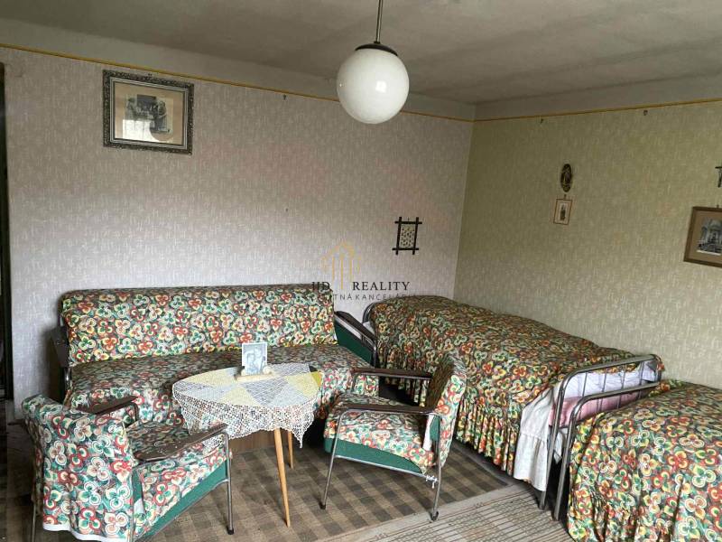 Szoba egy családi házban retro bútorokkal, mintás kárpitokkal és szőnyeggel.