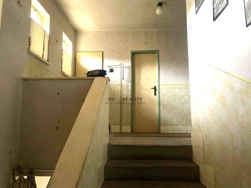 Egyszerű lépcső egy családi házban, minimalista belső térrel és világos falakkal.