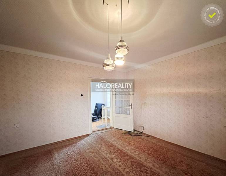 Szoba családi házban szőnyegpadlóval és függő világítással.