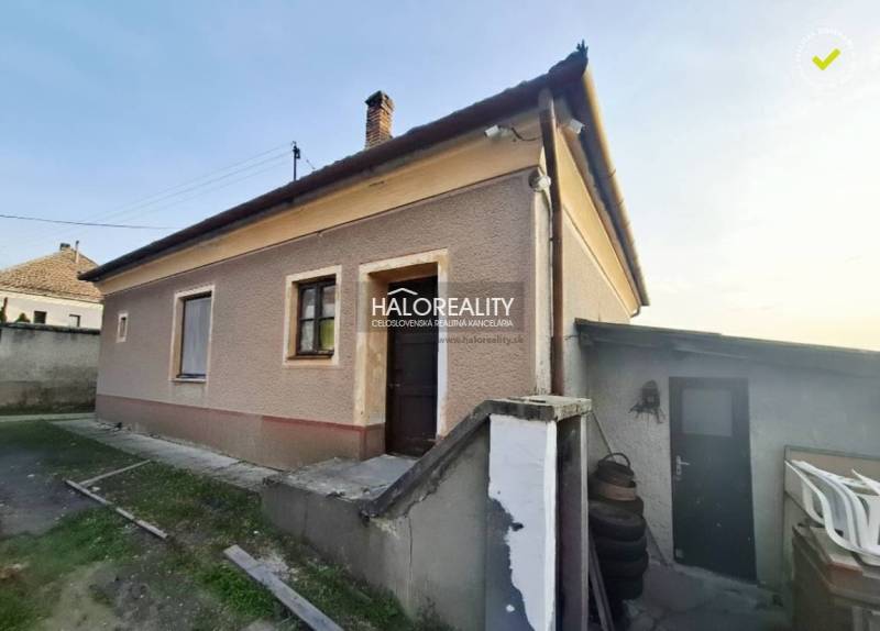 Családi ház Udvardon vakolt homlokzattal, külső lépcsőkkel és udvarral.