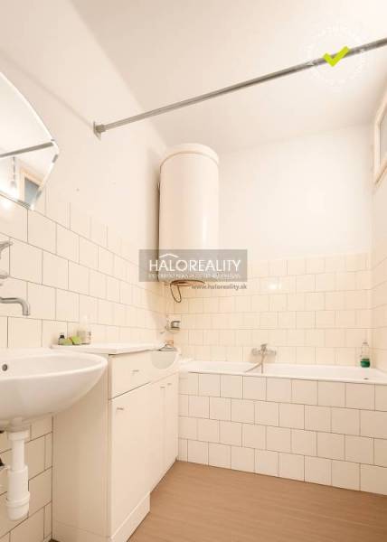 Fürdőszoba családi házban káddal, mosdóval és fa dekorációjú padlóval.