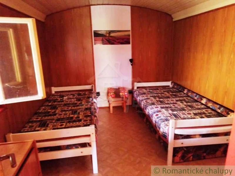 Faház belső két ággyal és fa dekorációjú padlóval.