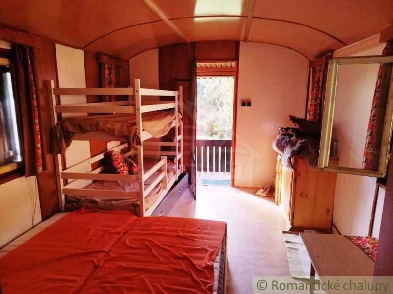 Négyágyas faház belső tere világos kilátással a teraszra.