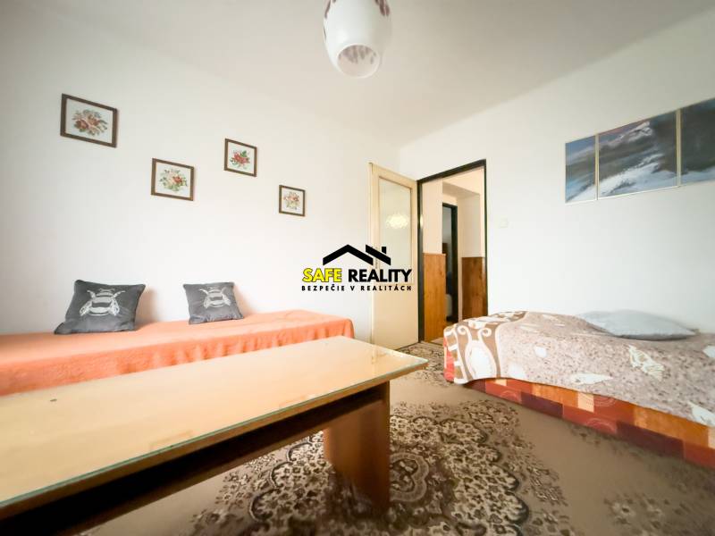 Nappali egy családi házban szőnyeggel és rajzokkal a falon.