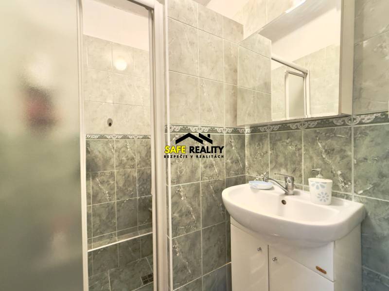 Fürdőszoba mosdóval és zuhanyzóval egy családi házban.