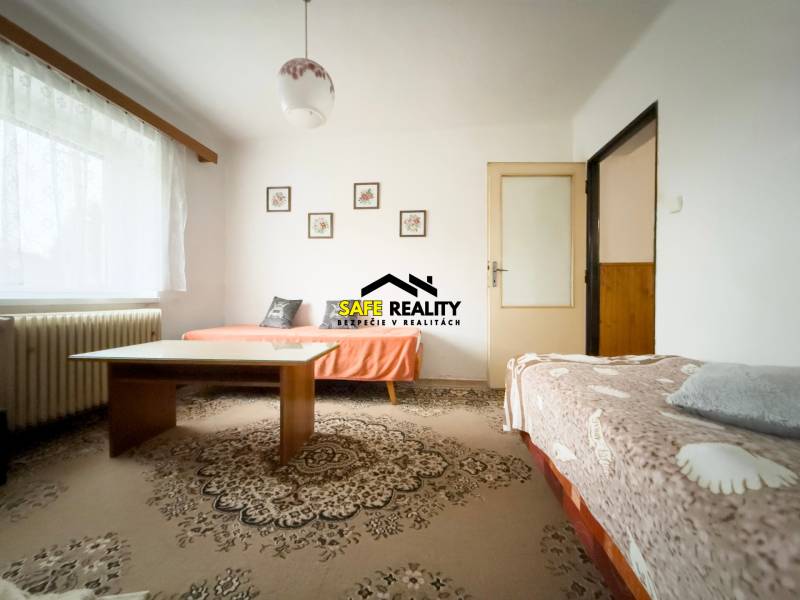 Nappali családi házban két kanapéval és egy asztallal a szőnyegen.