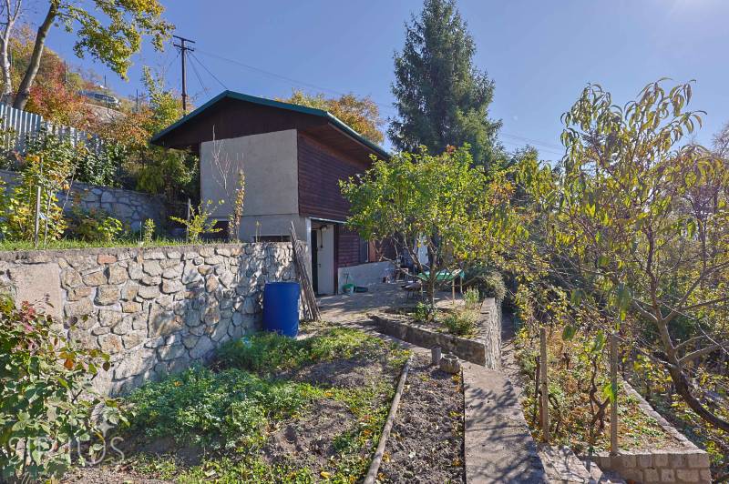 Kertek Pozsonyban - Dévényben a Spätna úton, kőfal, fák és növényzet.