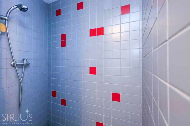 Zuhanykabin kék és piros csempékkel, kertek.