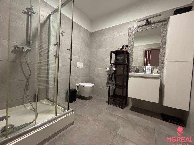 A modern zuhanyzóval és higiéniai szükségletek számára kialakított hellyel rendelkező kétszobás lakás fürdőszobája.