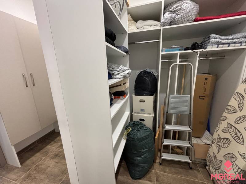 Skladolási tér a kétszobás lakásban polcokkal, lépcsőkkel és dobozokkal.