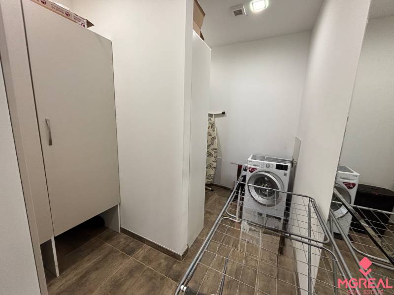 Mosógéppel, szárítóval és szekrénnyel ellátott fülke egy kétszobás lakásban; fa dekorációjú padló.