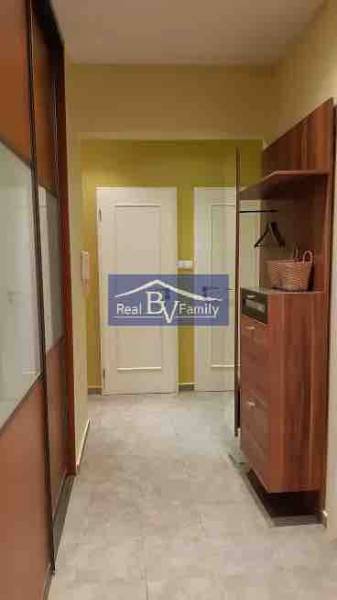 Folyosó egy 2 szobás lakásban tárolóhellyel és világos padlóval.