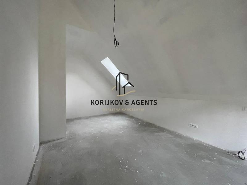 Tetőtéri szoba családi házban, mennyezeti ablakkal és elektromos aljzatokkal.