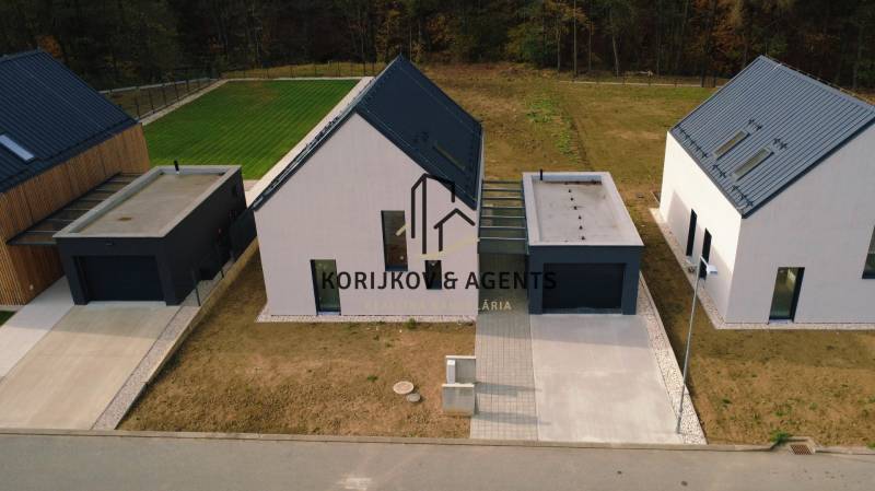 Családi házak a Pod Drieňovou utcában, Kamenica nad Cirochou-ban, gyep és bevezető út által körülvéve.