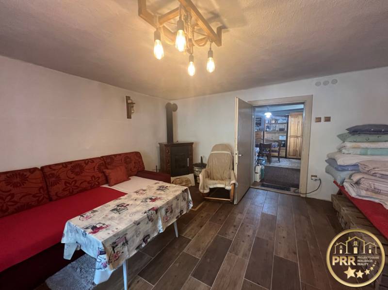 Kényelmes szoba a házban, hangulatos ülőhellyel, kandallóval és fából készült mennyezettel.