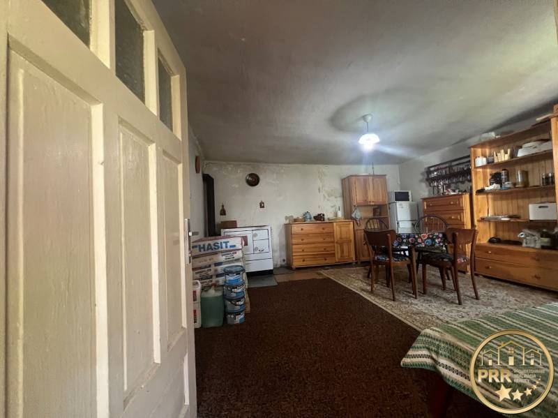 Belső tér fából készült bútorokkal, szőnyeggel, asztallal és a faház rusztikus hangulatot áraszt.