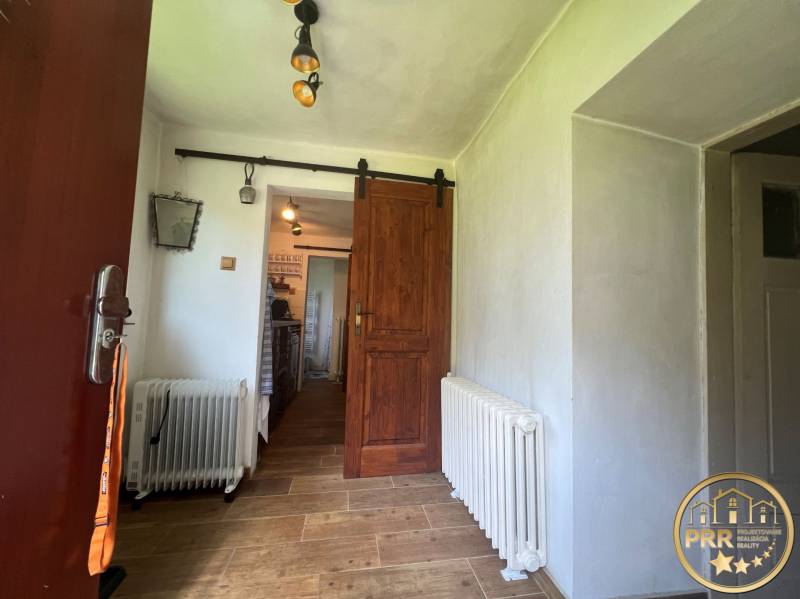 A fahatású padlóval, radiátorral és tolóajtóval rendelkező házikó belseje.