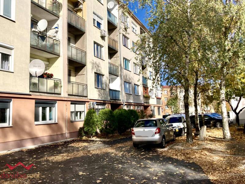 Lakóház a Komáromi Mederčská utcában parkoló autókkal és fákkal.