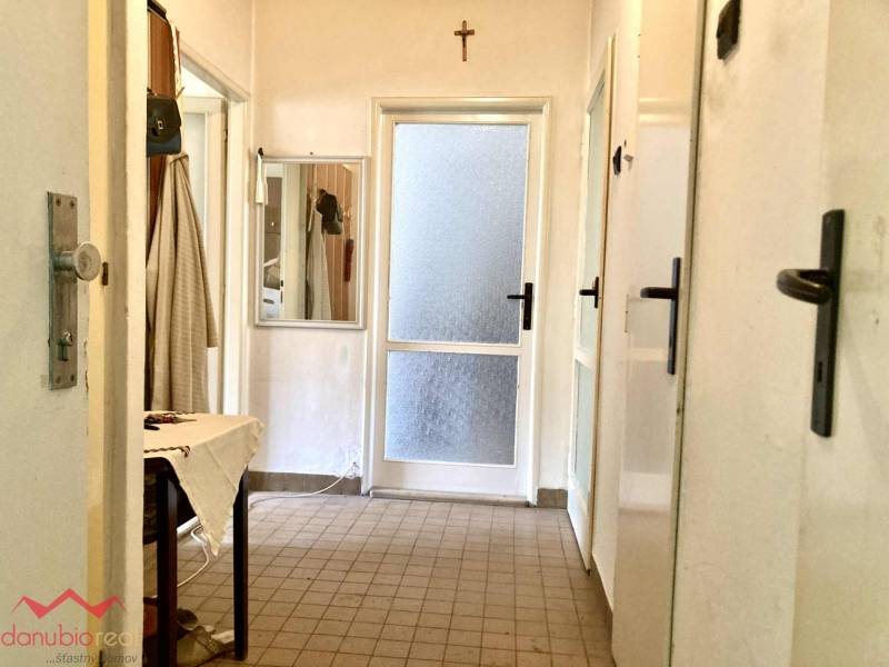 Folyosó egy 3 szobás lakásban csempével, tükörrel és vászon asztallal.