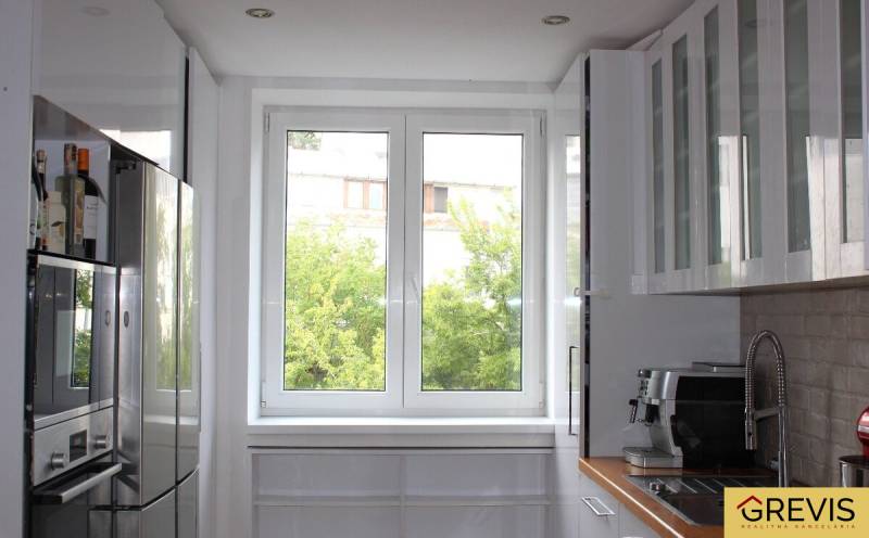 Konyha egy háromszobás lakásban, világos ablakokkal és modern készülékekkel.