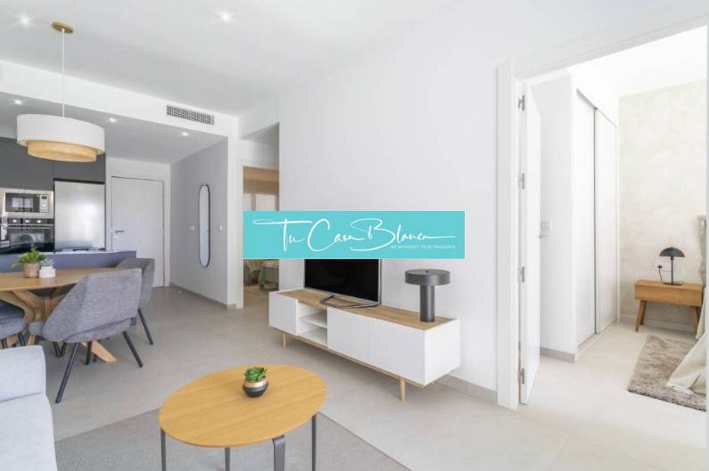 Nyaraló apartman nyitott nappalival, étkezőasztallal és fa dekorációjú padlóval.