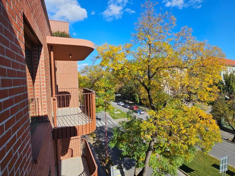 Kilátás egy téglaépület erkélyéről az utcára Pozsony-Ružinovban, Košická.