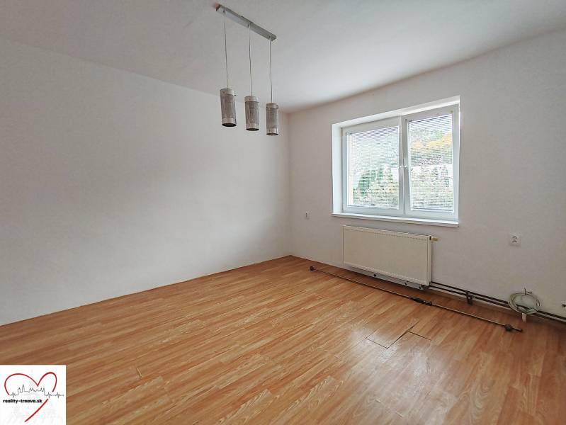 Szoba egy családi házban, fa dekorációjú padlóval és nagy ablakkal.