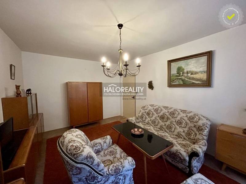 Nappali egy négy szobás lakásban klasszikus bútorokkal és elegáns csillárral.