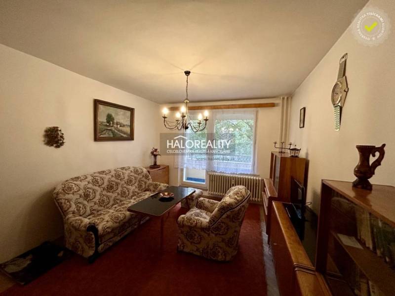 Nappali egy 4 szobás lakásban kényelmes bútorokkal, képpel, csillárral és kilátással.