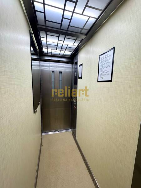 Lift megvilágított mennyezettel és rozsdamentes acél ajtókkal.