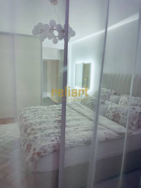 Hálószoba egy háromszobás lakásban ággyal, szekrénnyel és tükörrel.