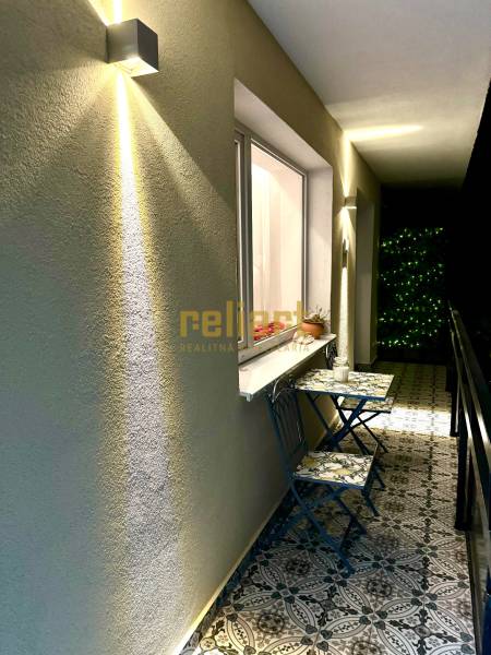 3 szobás lakás erkélye dekoratív csempékkel és fali világítással.