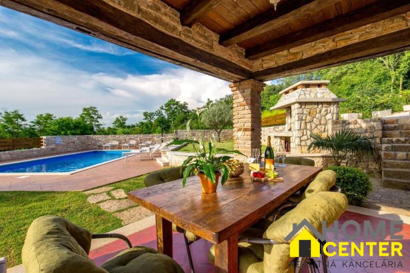 Egy villa külső része Bale városában medencével, asztallal és természeti részletekkel.