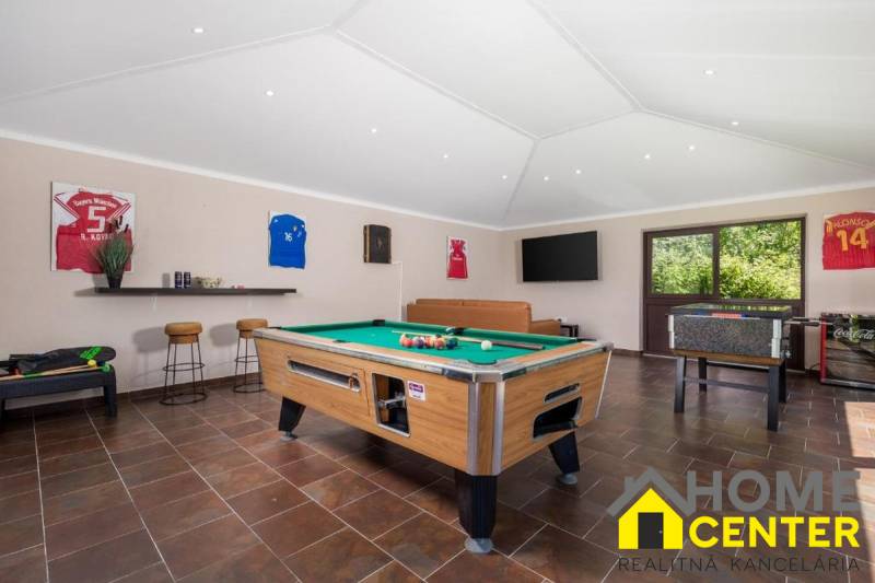 Villa belső tér biliárdasztallal, bőrkanapéval és fa dekorációjú padlóval.
