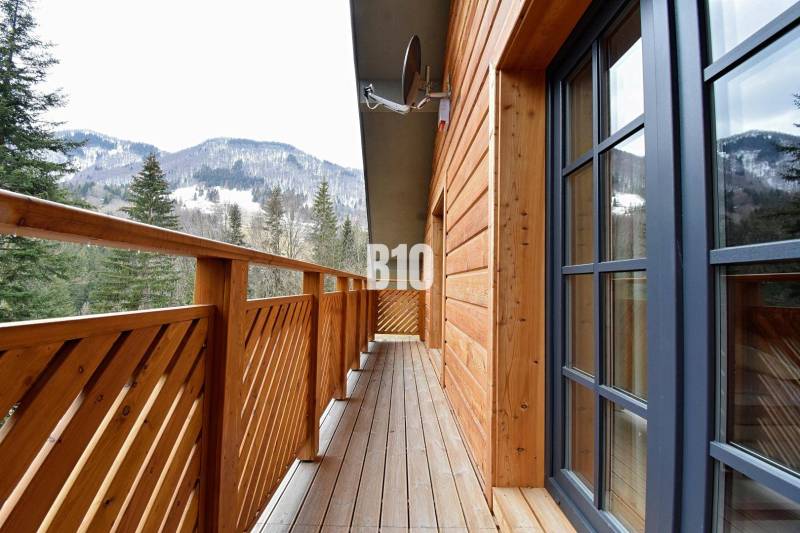 A terchovai ház erkélye kilátással a havas hegyekre és erdőkre.