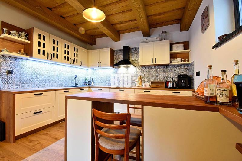 Konyha egy faháznál, fa mennyezettel, fa dekoros padlóval és kék csempékkel.