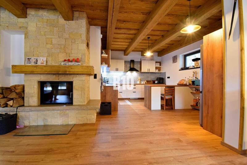 A kunyhó belső tere cserépkályhával, fa mennyezettel és fa dekorációjú padlóval.