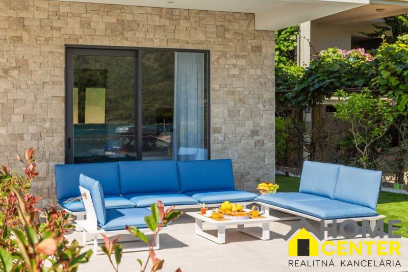 A villa külső része Bale-ban kék kerti ülőgarnitúrával és kőfallal.