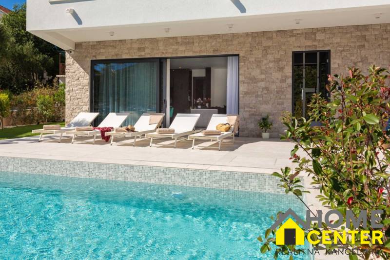 Egy villa külső része Baléban medencével és napozóágyakkal a teraszon.