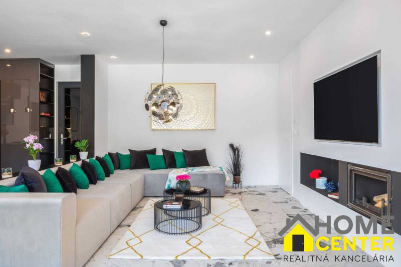 Nappali kényelmes kanapéval, kandallóval és dekorációkkal a villában.