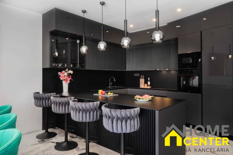Fekete konyha a villában márványpadlóval és luxus székekkel.