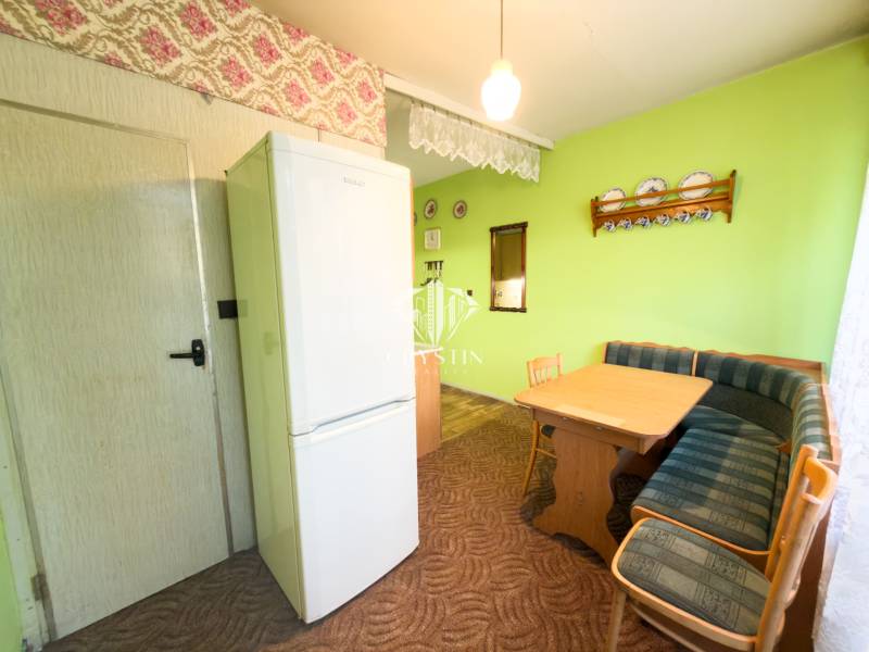 Étkező sarok kanapéval és asztallal egy háromszobás lakásban.