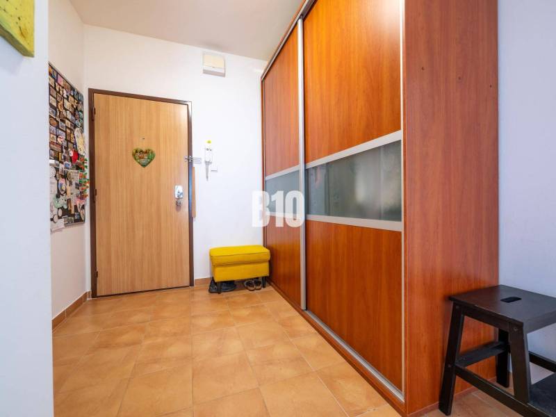 Folyosó egy 4 szobás lakásban, csempével és beépített szekrénnyel.