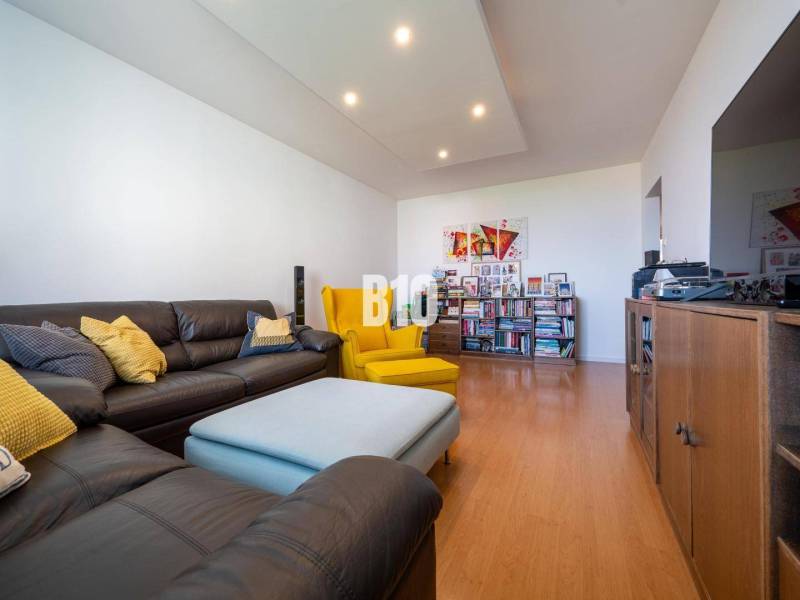 Nappali egy négyszobás lakásban, fa dekorációjú padlóval és kényelmes ülőhelyekkel.