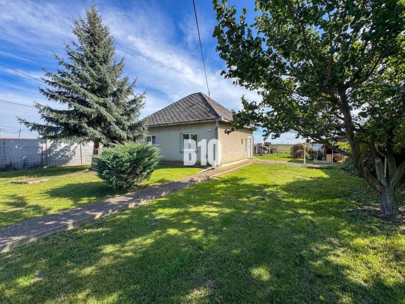 Családi ház Ondrejovceban, amelyet zöld gyep és fák vesznek körül a tágas kertben.